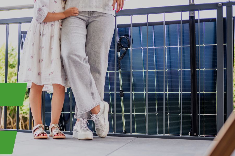 Zwei Menschen stehen vor einem bifazialen Balkonkraftwerk